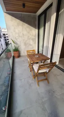 a patio with a wooden table and chairs on a balcony at Superbe studio avec une belle terrasse à Gauthier in Casablanca