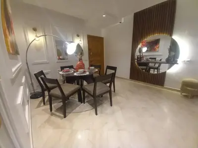 a dining room with a table and chairs and a mirror at Appartement la perle de Nouaceur in Nouaceur