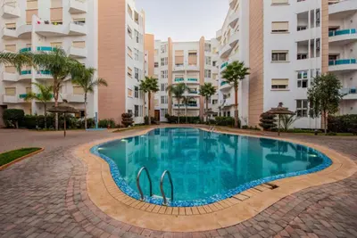 a swimming pool in front of a apartment building at Appartement la perle de Nouaceur in Nouaceur