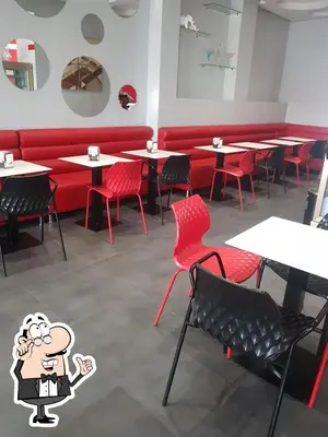 a restaurant with red chairs and tables with red booths at Appartement la perle de Nouaceur in Nouaceur