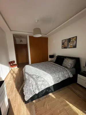 a bedroom with a large bed and a wooden floor at Ocean Palm Aρραrt Pοοl Vieω in Casablanca