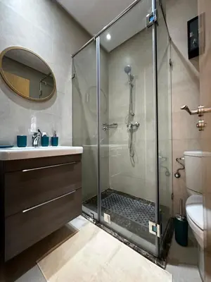 a bathroom with a shower with a sink and a toilet at Ocean Palm Aρραrt Pοοl Vieω in Casablanca