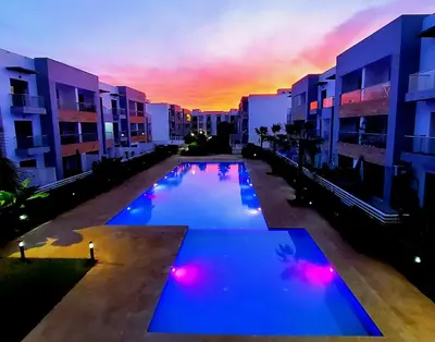 a large swimming pool with a sunset in the background at Ocean Palm Aρραrt Pοοl Vieω in Casablanca