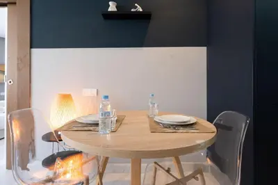 a dining room table with chairs and a wooden table with water bottles at super appartement with parking c4 in Casablanca