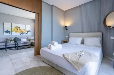 a bedroom with a large white bed and a living room at super appartement with parking c4 in Casablanca