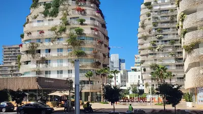 a tall building with plants on the side of it at Magnifique appartement Casa Finance City in Casablanca