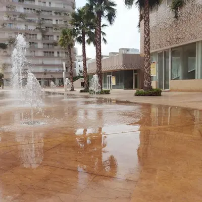 a fountain in a courtyard with palm trees and a building at Magnifique appartement Casa Finance City in Casablanca