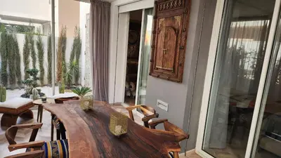 a dining room with a wooden table and chairs at Magnifique appartement Casa Finance City in Casablanca
