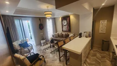 a kitchen and living room with a couch and a table at Magnifique appartement Casa Finance City in Casablanca
