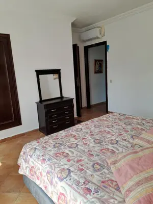 a bedroom with a bed and a dresser and a mirror at Villa de rêves in Casablanca