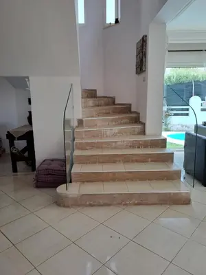 a staircase in a living room with a tile floor at Villa de rêves in Casablanca