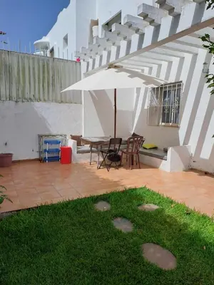 a patio with a table and a white umbrella at Villa de rêves in Casablanca