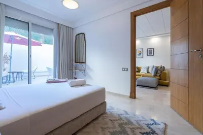 a bedroom with a large bed and a living room at Hot location flat at Maarif bd Anfa near Ahmet chef in Casablanca