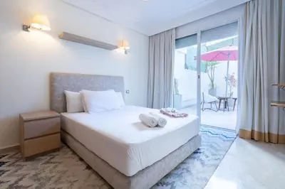 a bedroom with a bed and a balcony with an umbrella at Hot location flat at Maarif bd Anfa near Ahmet chef in Casablanca