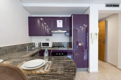 a kitchen with purple cabinets and a counter top at Hot location flat at Maarif bd Anfa near Ahmet chef in Casablanca