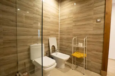 a bathroom with a toilet and a glass shower at Hot location flat at Maarif bd Anfa near Ahmet chef in Casablanca