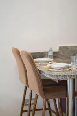 a table with two chairs and a marble counter top at Hot location flat at Maarif bd Anfa near Ahmet chef in Casablanca