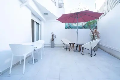 a patio with a table and chairs and an umbrella at Hot location flat at Maarif bd Anfa near Ahmet chef in Casablanca