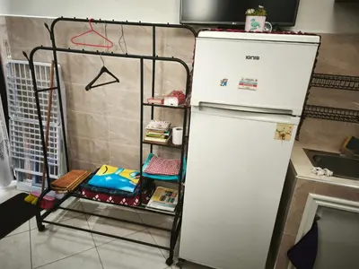 a white refrigerator in a kitchen next to a shelf at Garden Beet in Sidi Rahal