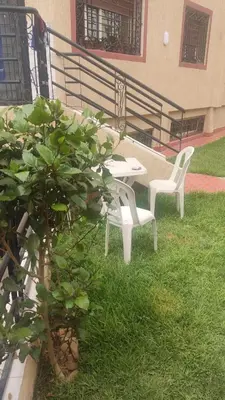two white chairs and a table and a plant at Garden Beet in Sidi Rahal