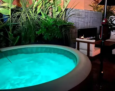 a hot tub in a garden with a fireplace at Superbe Appartement avec piscine et jacuzzi privé in Casablanca