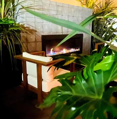 a fireplace in a living room with a chair and a table at Superbe Appartement avec piscine et jacuzzi privé in Casablanca