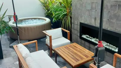 a patio with a fireplace and a chair and a tub at Superbe Appartement avec piscine et jacuzzi privé in Casablanca