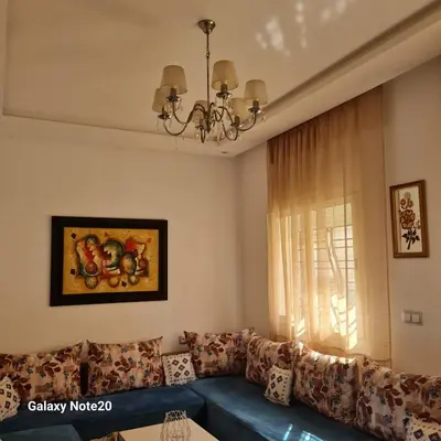 a living room with a blue couch and a window at Chez Najib et Ziad in Temara
