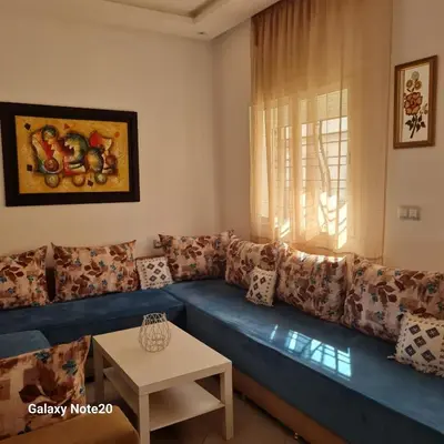 a living room with a blue couch and a table at Chez Najib et Ziad in Temara