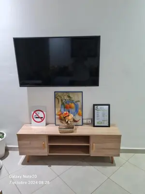 a entertainment center with a flat screen tv on a wall at Chez Najib et Ziad in Temara
