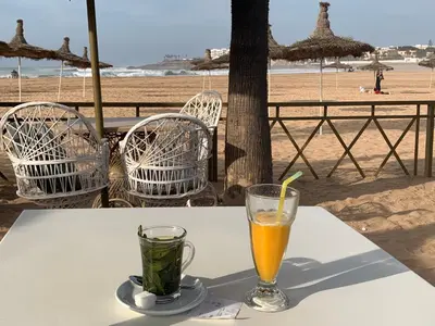a table with two drinks on top of the beach at Appartement de standing vue sur mer à Mohammedia in Mohammedia