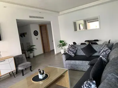 a living room with a couch and a table at Appartement de standing vue sur mer à Mohammedia in Mohammedia