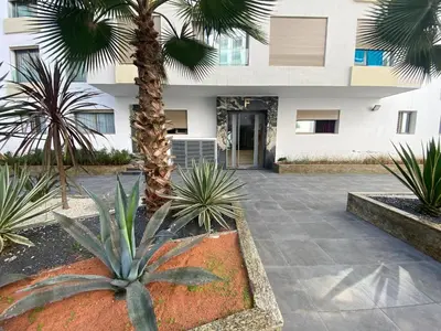 a courtyard with palm trees in front of a building at CORNICHE CASABLANCA - SUBLIME F2 NEUF in Casablanca