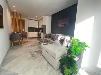 a living room with a white couch and a table at CORNICHE CASABLANCA - SUBLIME F2 NEUF in Casablanca