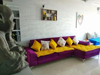 a purple couch with yellow pillows in a living room at Appartement sidi rahal in Berrechid