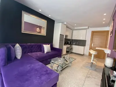 a living room with a purple couch and a table at CORNICHE CASABLANCA - VINTAGE F2 NEUF in Casablanca