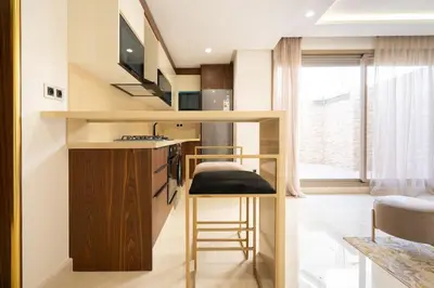 a small kitchen with a bar with a sink and a stool at Luxury one bedroom in Maarif one in Casablanca