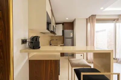 a kitchen with a counter with a sink and a refrigerator at Luxury one bedroom in Maarif one in Casablanca