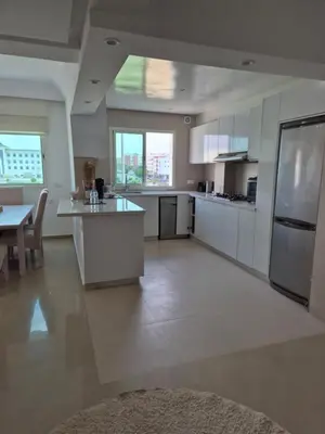 a large kitchen with white cabinets and a table at My Cosy Place Rabat - Cosy Home Wifak Temara in Temara