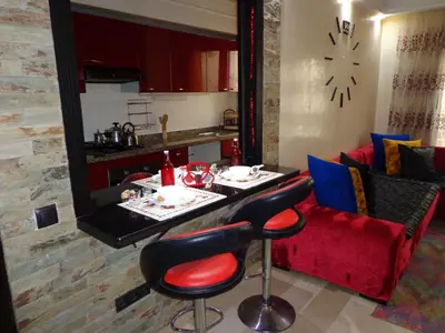a living room with a table and a red couch at Zen Home in Casablanca