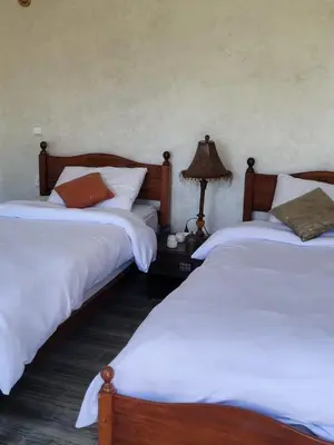 a bedroom with two beds and a lamp on a table at Jnane Ville Verte in Casablanca
