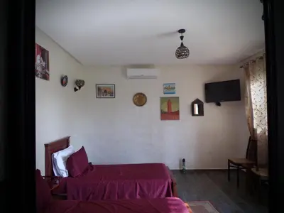 a bedroom with a bed and a tv on the wall at Jnane Ville Verte in Casablanca