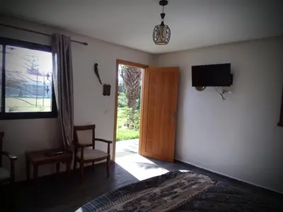 a bedroom with a door and a tv on the wall at Jnane Ville Verte in Casablanca