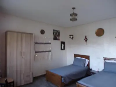a bedroom with two beds and a sliding door at Jnane Ville Verte in Casablanca