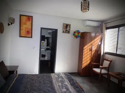 a bedroom with a bed and a chair and a mirror at Jnane Ville Verte in Casablanca