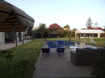 a patio with chairs and a swimming pool at Jnane Ville Verte in Casablanca