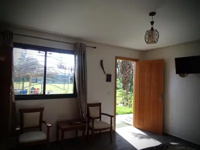 a room with a window and two chairs and a door at Jnane Ville Verte in Casablanca
