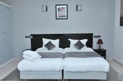 a bedroom with two beds with white sheets and pillows at EAST WEST HOTEL in Casablanca