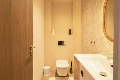 a bathroom with a toilet and a sink and a mirror at Metropolitan 06-Two Bedrooms - Cavalli Luxury Flat in Casablanca