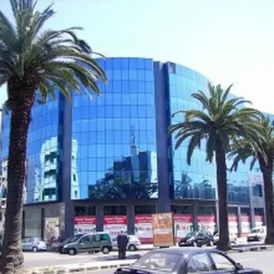 a car parked in front of a building with palm trees at Nice Apartment For Families- Bd Ghandi- Casablanca in Casablanca
